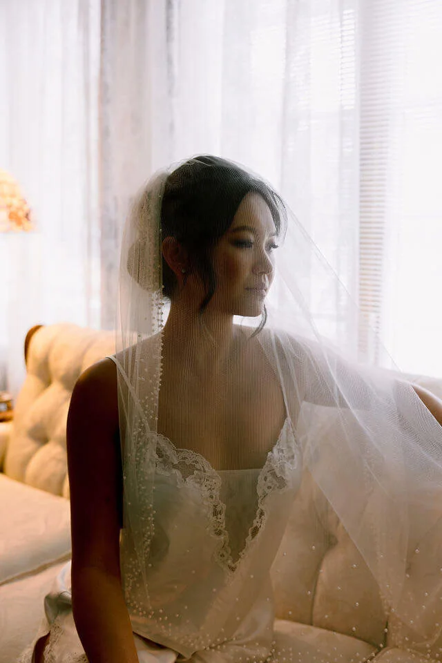 Bride in white gown seated on a couch